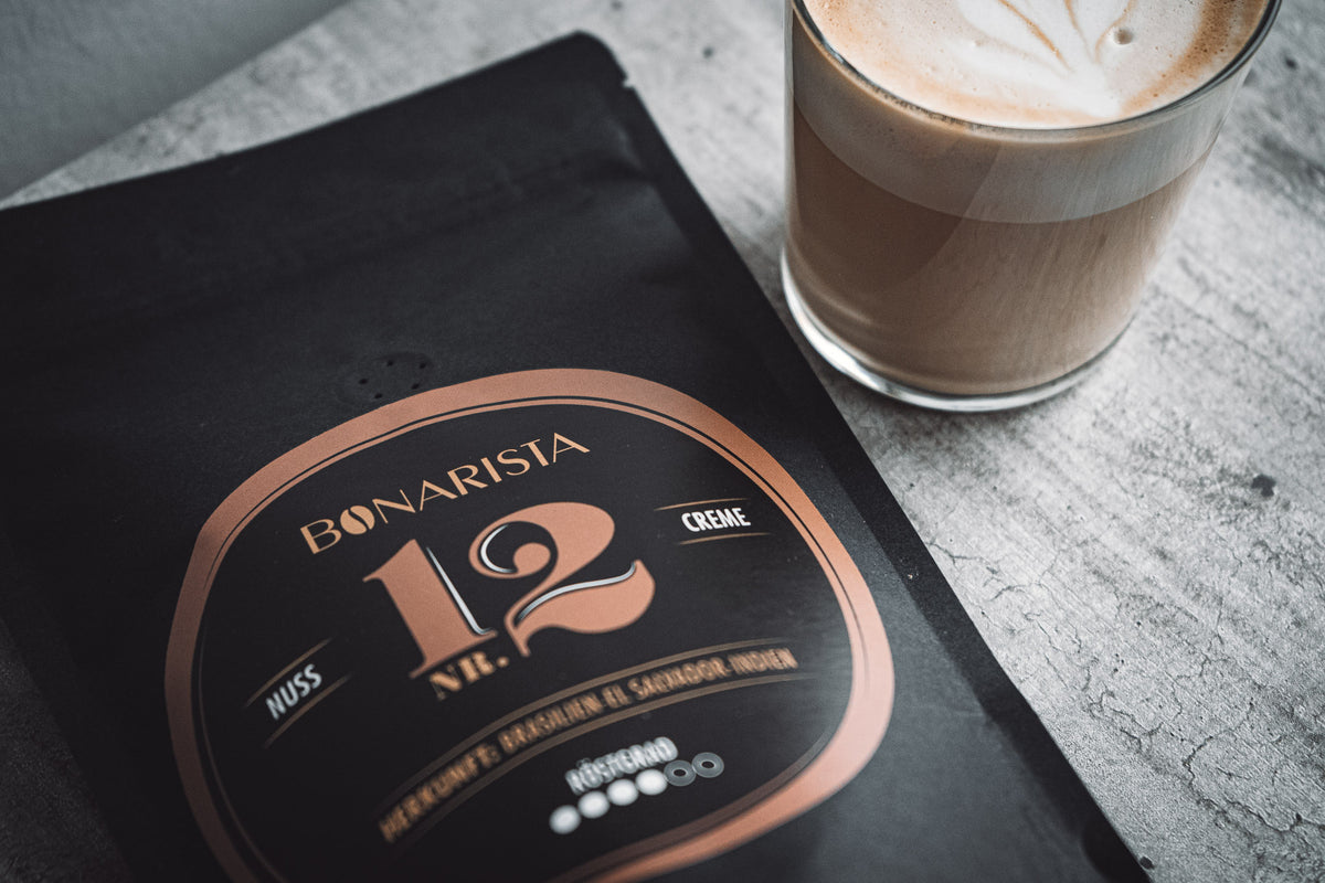 Bonarista Kaffeepackung Nr.12 neben einer Tasse Cappuccino auf einem Tisch 